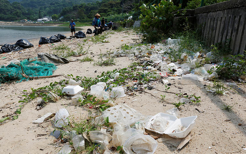 Workers clean Nim Shue Wan beach at Hong Kong’s Lantau Island. Environmentalists claim trash is washed ashore from mainland China, July 8, 2016. Bobby Yip/VCG