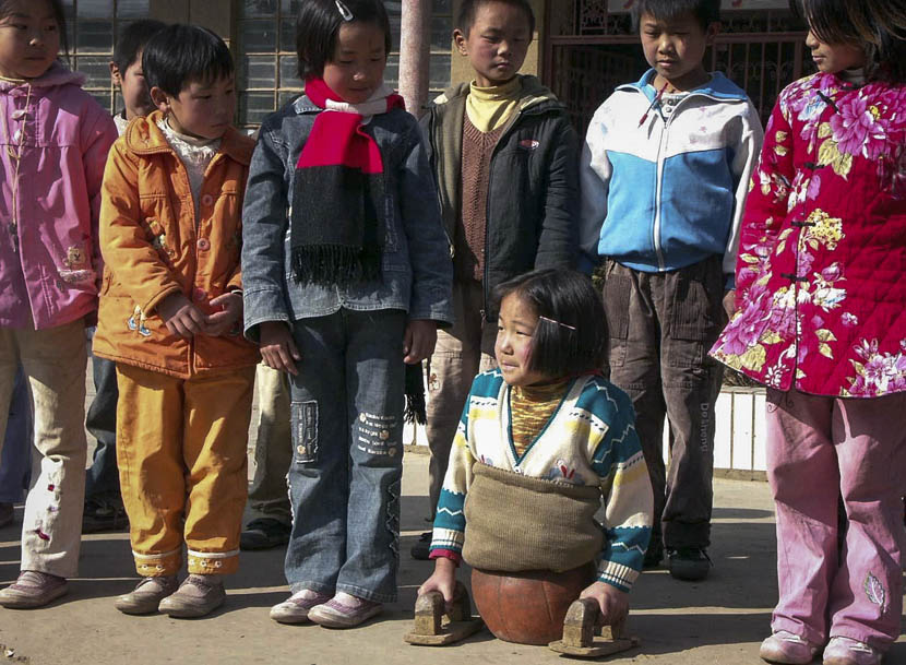 Qian Hongyan’s classmates stare down at her, Luliang County, Yunnan province, Jan. 4, 2005. VCG 