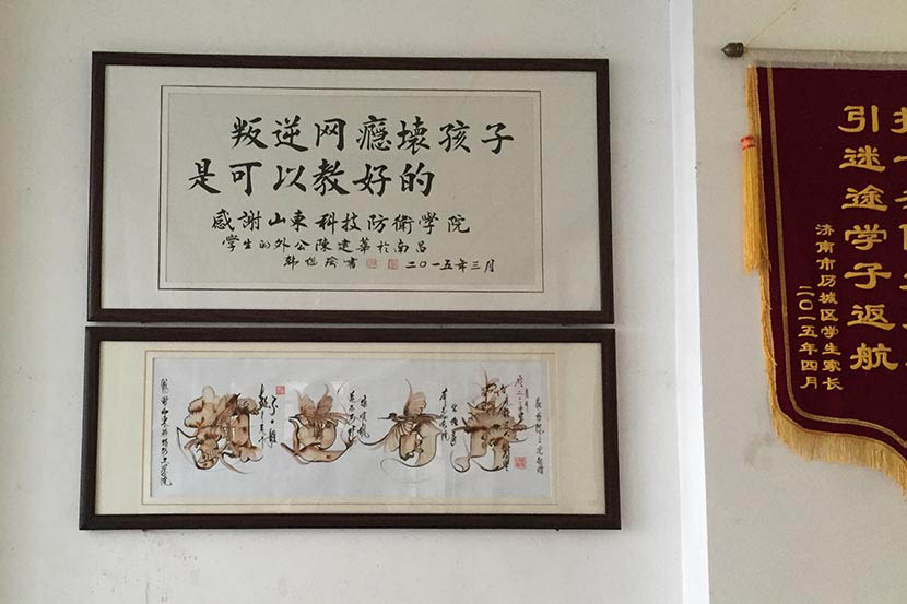  A framed piece of traditional calligraphy hanging in the school reads: ‘Rebellious, bad children who are addicted to the internet can be made good again,’ at Shandong Science and Technology Defense College in Jinan, Sept. 21, 2016. Owen Churchill/Sixth Tone