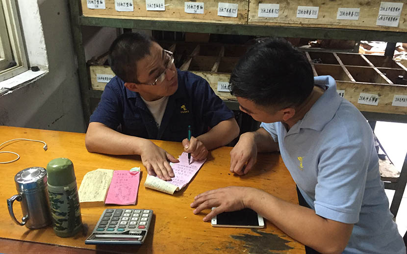Dong Ming writes notes in order to communicate with his deaf colleague at the factory in Tongling, Anhui province, Sept. 23, 2016. Fu Danni/Sixth Tone
