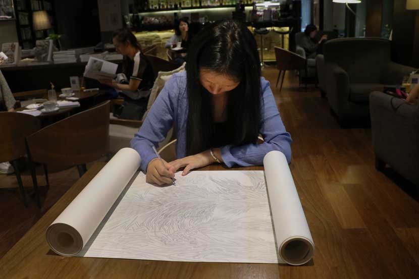 Ji Hongyan draws on a scroll at One Way Space bookshop in Beijing, Sept. 21, 2016. Yin Yijun/Sixth Tone