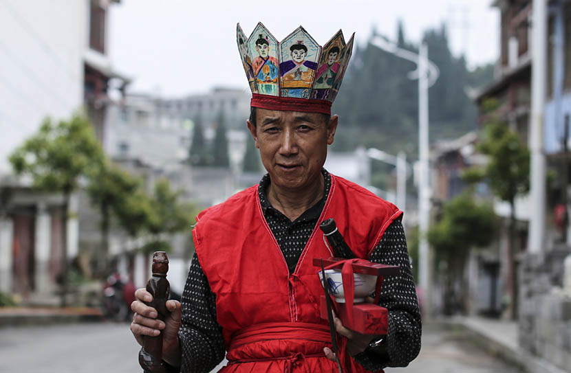 Zhang Maoqing, dressed in his Nuo opera costume, shows ceremonial objects in Shaowo Town, Guizhou province, June 14, 2016. Li Kun/Sixth Tone