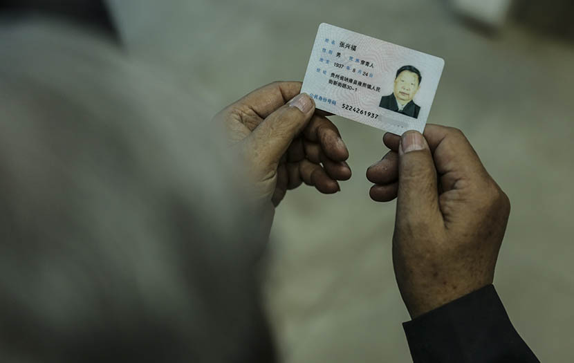 A man shows his identity card on which his ethnicity reads as “Chuanqing” in Shaowo Town, Guizhou province, June 14, 2016. Li Kun/Sixth Tone