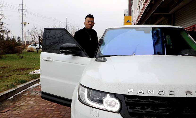 Yu Li stands by his Range Rover in Gongzhuling, Jilin province, Nov. 10, 2016. Yin Yijun/Sixth Tone