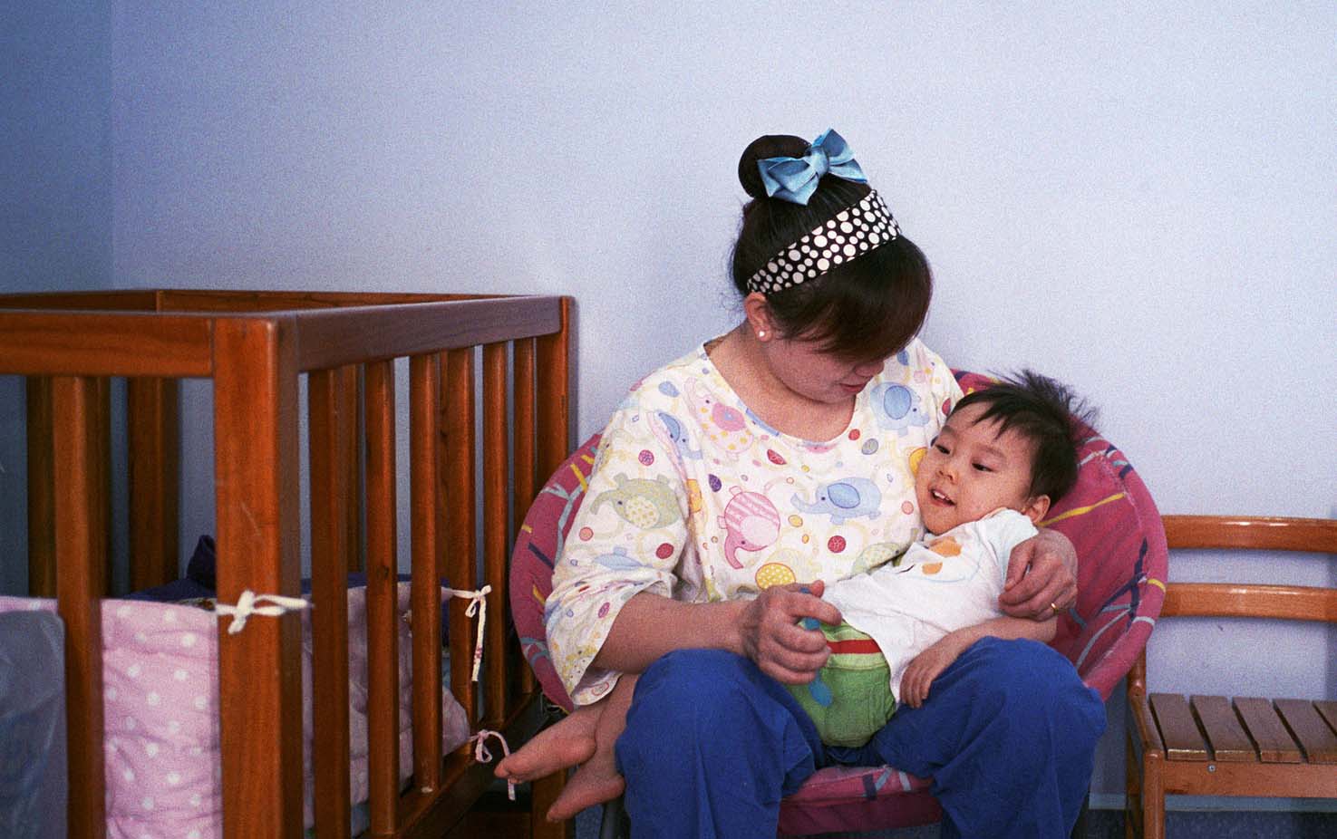 A professional caretaker holds a young patient at Butterfly Children’s Hospices in Changsha, Hunan province, May 30, 2013. Zhong Ruijun/Southern Metropolis Daily/IC