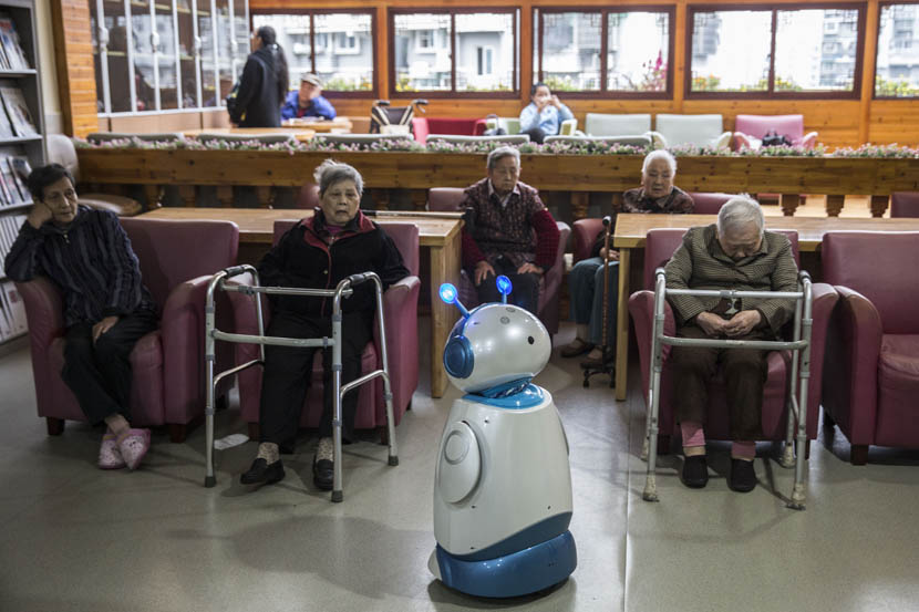 The robot Ah Tie ‘stands’ in front of a group of elderly people at the Hangzhou Social Welfare Center, Zhejiang province, Oct. 28, 2016. Chen Ronghui/Sixth Tone