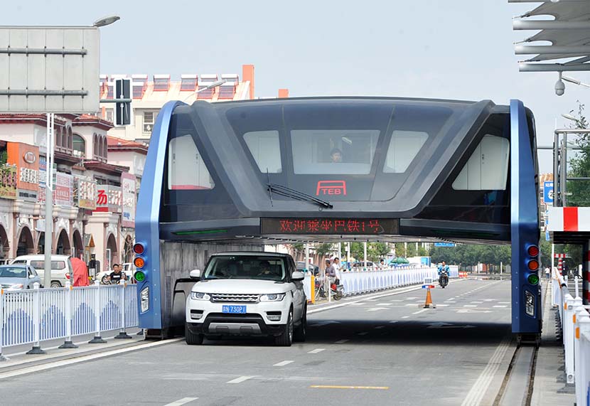 An SUV drives underneath the ‘Transit Elevated Bus’ in Qinhuangdao, Hebei province, Sept. 5, 2016. VCG