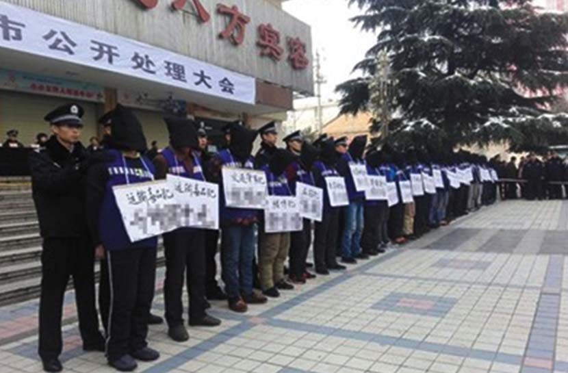 Criminal suspects wear signs displaying their names and charges during the public sentencing in Xingping, Shaanxi province, Nov. 25, 2016. @Zhoupengan from Weibo