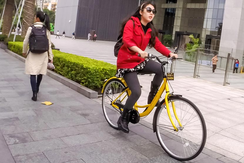 A woman rides an Ofo bike in Shenzhen, Guangdong province, Nov. 25, 2016. Liang Xiashun/VCG