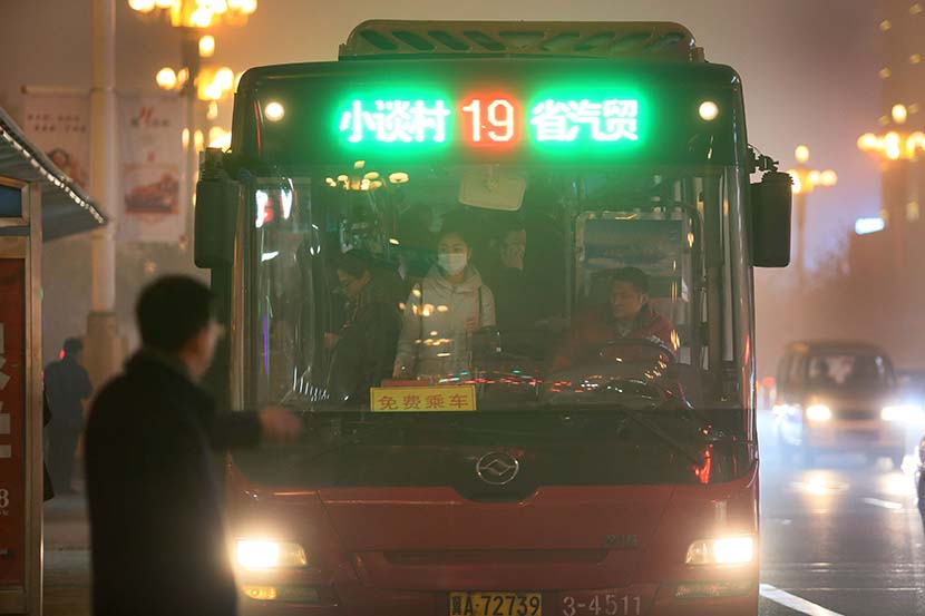 A man waits for a bus in Shijiazhuang, Hebei province, Dec. 19, 2016. The city implements an even-odd license plate plan to limit vehicles on the road and offers free bus service to citizens during heavy air pollution days. Xie Kuangshi/Sixth Tone
