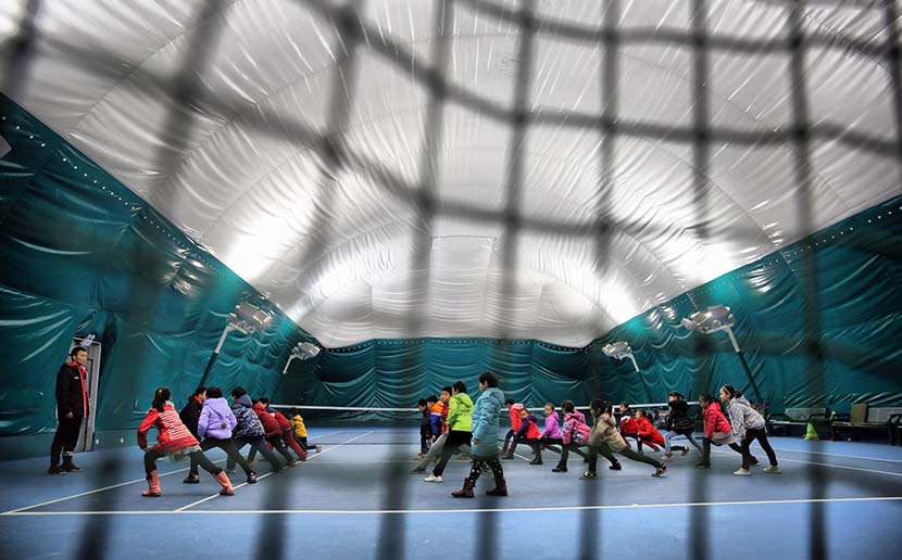 Students at Huaxing Primary School attend gym class in an indoor stadium to avoid the smog in Shijiazhuang, Hebei province, Dec. 9, 2016. The primary school built the stadium with a ceiling that can filter out small pollution particles. IC