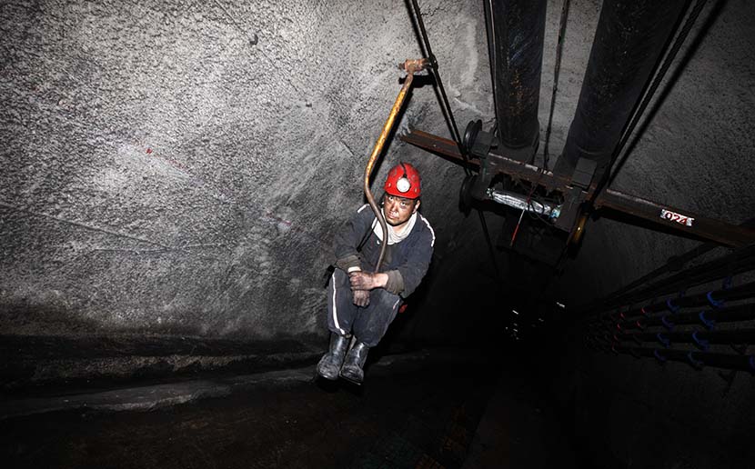 A worker descends into a coal mine using a simple elevator device in Suzhou, Anhui province, June 16, 2016. Hoo Mei/VCG