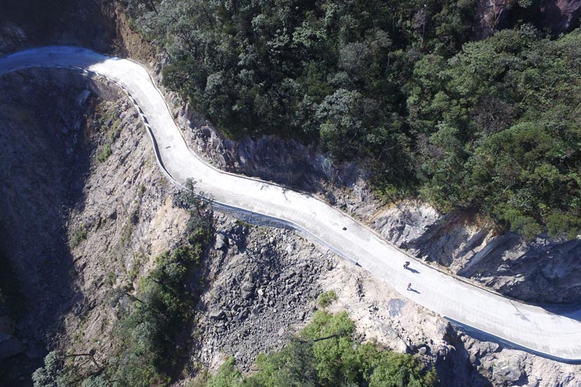 An aerial photo shows people traversing the road built on Shikengkong Mountain in the Nanling National Nature Reserve, Guangdong province, Dec. 6, 2016. Yang.W/Greenpeace for Sixth Tone