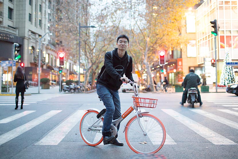 Michael Yao, Mobike general manager for Shanghai, poses for a photo on a Mobike shared bicycle, Shanghai, Dec. 14, 2016. Zhou Pinglang/Sixth Tone