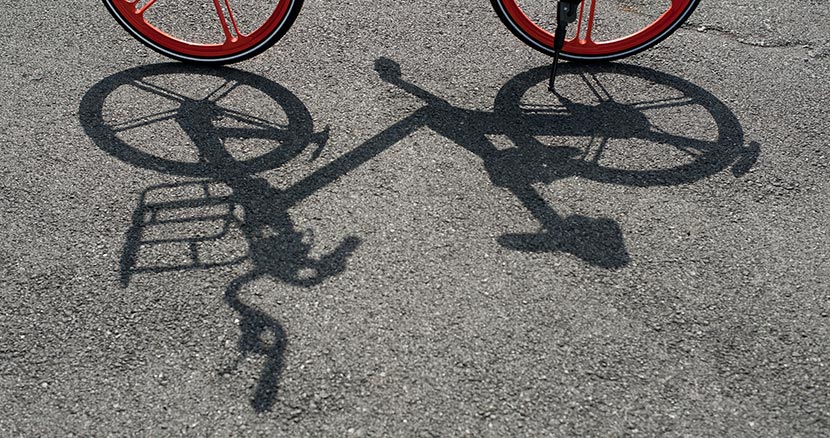 The shadow of a Mobike shared bicycle is seen on the ground, Shanghai, Aug. 13, 2016. Long Liu/VCG