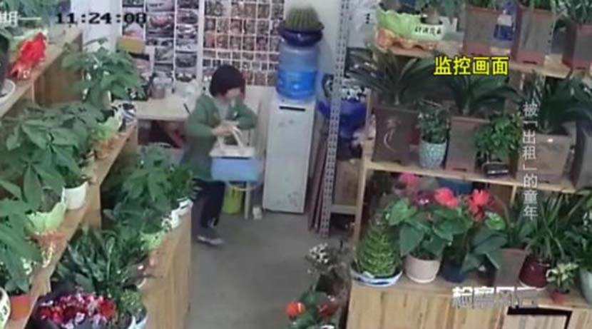 A screenshot from store surveillance footage shows a girl grabbing the blue handbag that the owner left in the shop.