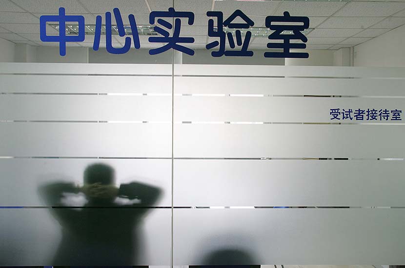 A man sits in a testing room for subjects, waiting for the results of CD4 cell testing, at a hospital in Shanghai, Dec. 6, 2006. Xu Haifeng/Sixth Tone