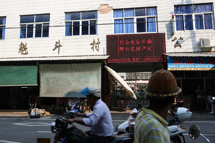 The message ‘Fight against telecom fraud and protect people’s fortunes’ is displayed on a screen in Kuidou Town, Anxi County, Fujian province, Aug. 28, 2016. Jia Yanan/Sixth Tone