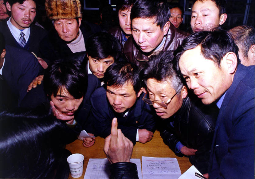 A group of farmers listen to an Yiwu entrepreneur giving business advice in Longyou, Zhejiang province, Feb. 8, 2001. Fu Yongjun/VCG