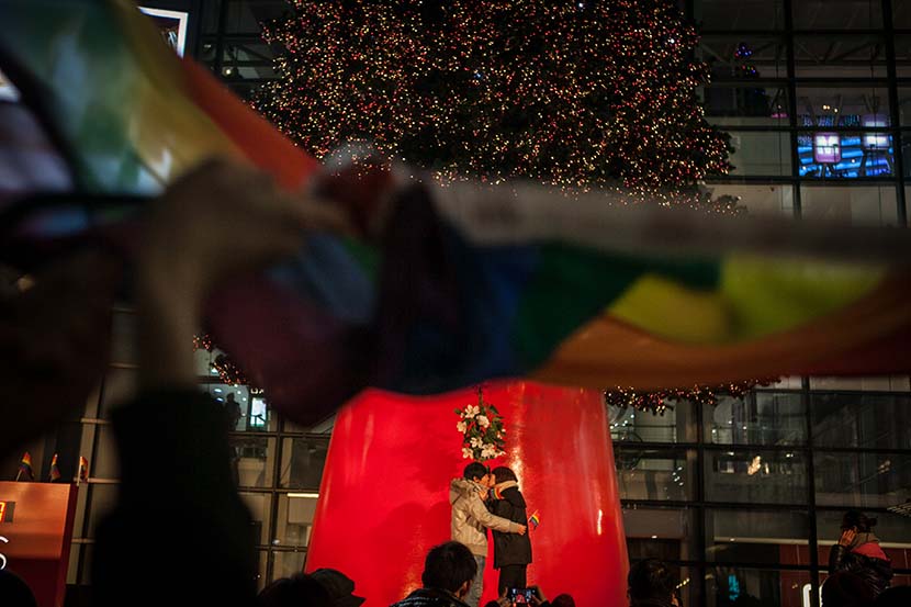 A lesbian couple kiss each other during an event in Shanghai, Dec. 22, 2013. Sun Zhan/Sixth Tone