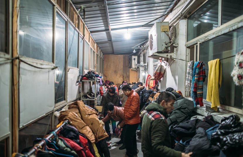 Migrant workers shop at a secondhand store in Pi Village, Beijing, Jan. 15, 2017. Zou Biyu/IC