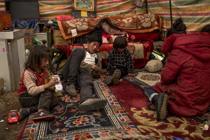 Members of the nomadic Sori family sit inside their living room tent at their winter camp in the Amdo region of the Tibetan Plateau, March 20, 2016. Luc Forsyth for Sixth Tone