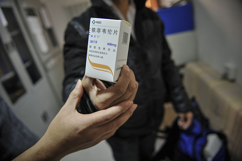 A person holds a package of free antiretroviral medication provided by the Chinese government, Tianjin, Nov. 23, 2016. You Sixing/VCG
