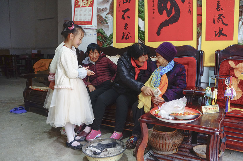 Neighbors offer lunar new year greetings to 112-year-old Huang Ma Kun in Bama County, Guangxi Zhuang Autonomous Region, Jan. 31, 2017. Fan Yiying/Sixth Tone