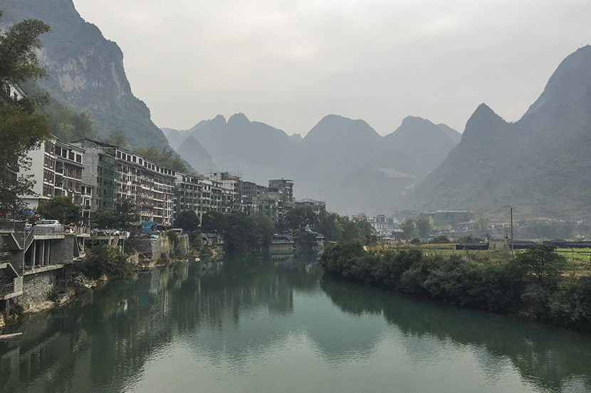 A view of Bapan Village and Panyang River in Bama County, Guangxi Zhuang Autonomous Region, Feb. 1, 2017. A number of high-rises have been built since 2009 to host the growing number of tourists. Fan Yiying/Sixth Tone