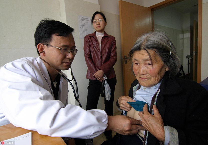 Hu Weimin takes a patient’s vital signs at a hospital in Loudi, Hunan province, April 23, 2006. IC