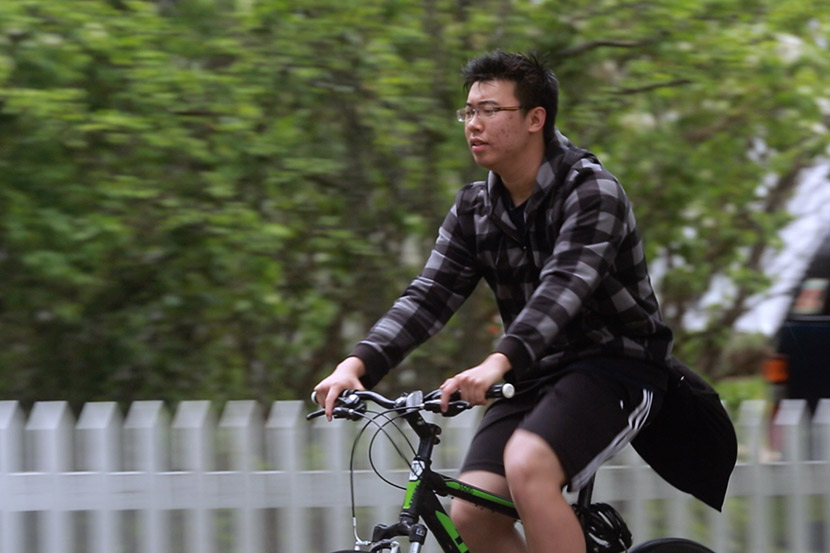 Harry rides a bike in a still from the documentary ‘Maineland.’ Courtesy of Wang Miao