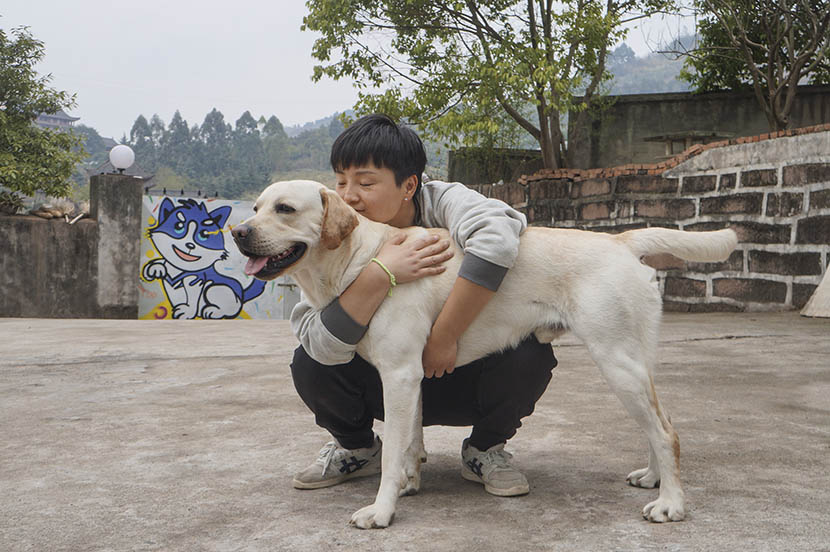 Fang Ling hugs Jian Jian at her dog hotel in rural Chengdu, Sichuan province, March 4, 2017. Fan Yiying/Sixth Tone