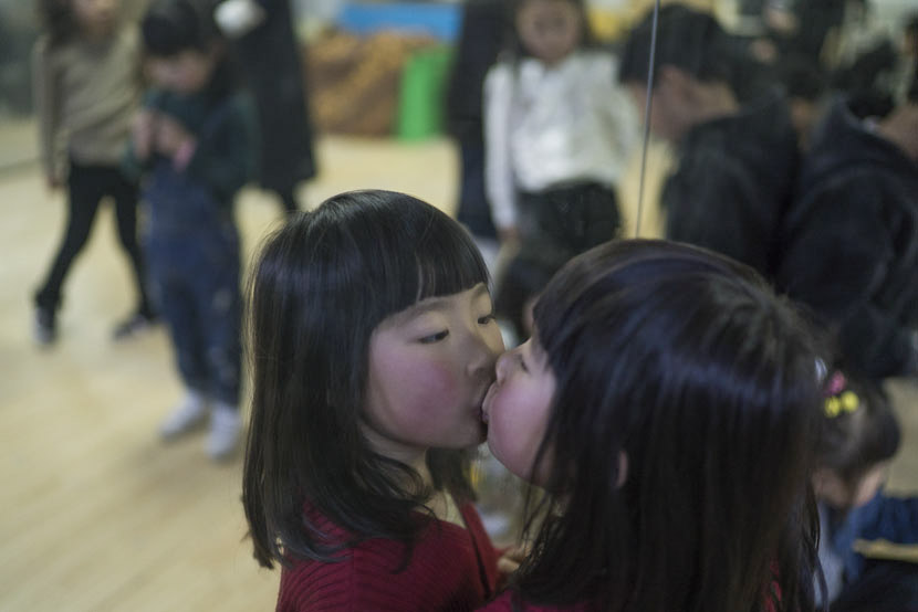 A girl kisses the mirror during the break of a child modeling class in Hangzhou, Zhejiang province, March 12, 2017. Wu Yue/Sixth Tone