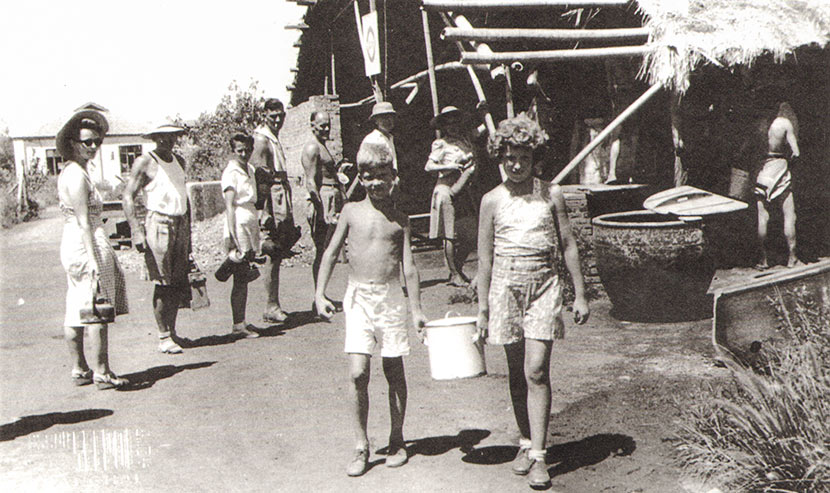 Children carry water from a hot water station in Lunghwa internment camp. Courtesy of Betty Barr