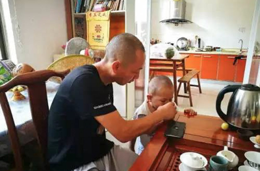 Dao Lu feeds a child at Husheng Xiaoju in Nantong, Jiangsu province. From WeChat public account Umalotus
