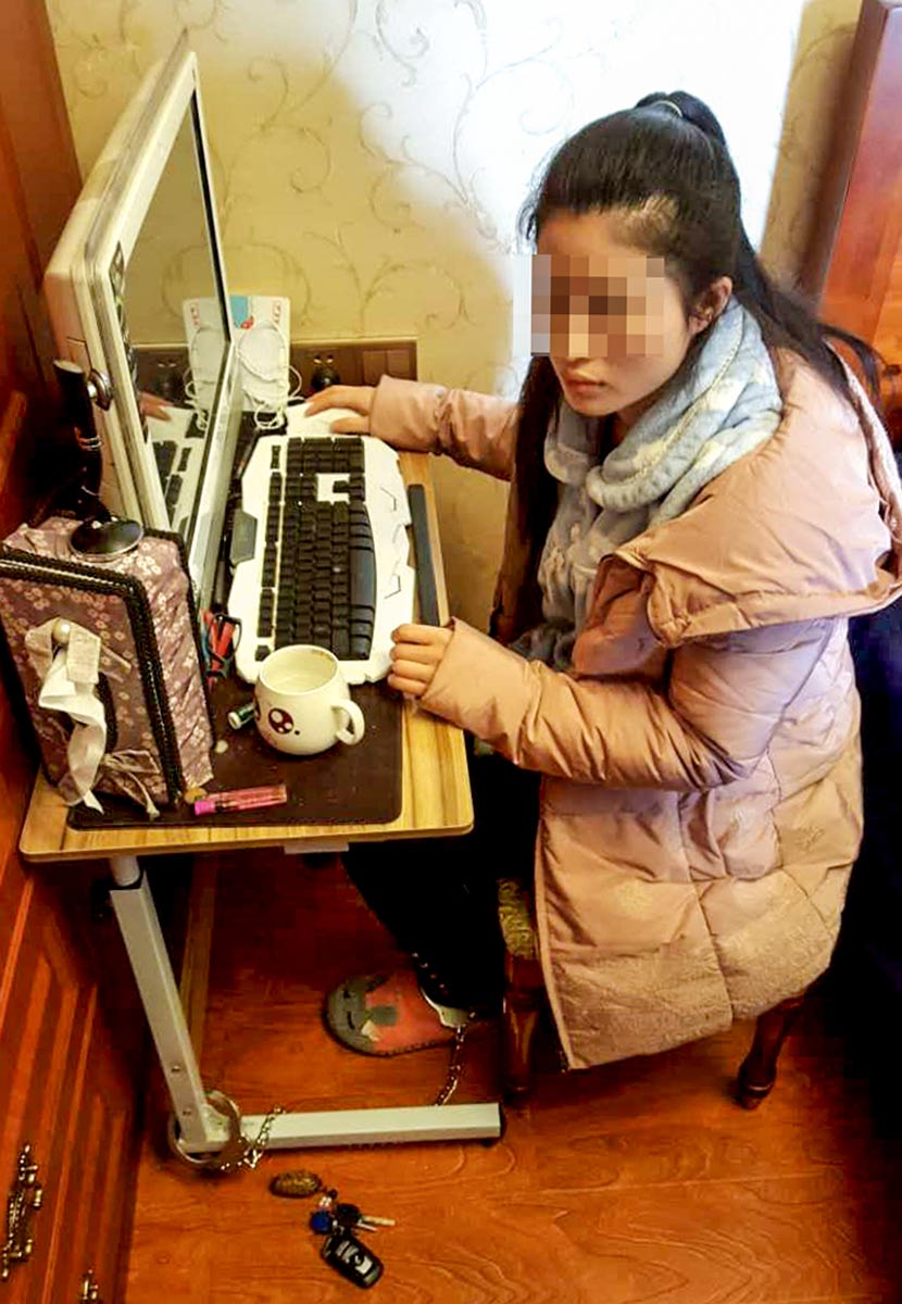 In a photo taken by a journalist accompanying local police, Ren Xin is seen shackled to a desk at the apartment she shares with her abusive husband in Chongqing, March 27, 2017. Chongqing Evening News/VCG