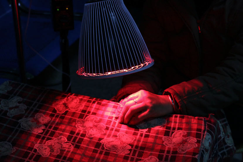 A village doctor uses infrared light to treat injuries and sore muscles in Gongcheng County, Guangxi Zhuang Autonomous Region, March 7, 2017. Cai Yiwen/Sixth Tone