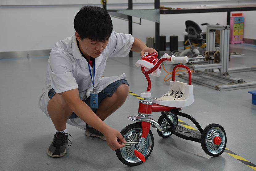 An employee at the Zhejiang Academy of Science and Technology for Inspection and Quarantine tests a toy following customer allegations that Niangao Mama had sold fake baby products, Hangzhou, Zhejiang province, 2016. Courtesy of Li Danyang
