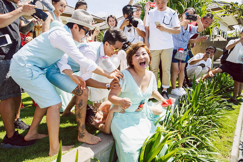 Liu Yan, lying on the ground, holds onto Jia Ling, also a bridesmaid, to avoid being thrown into a swimming pool during Bao Beier’s wedding in Bali, Indonesia, March 30, 2016. VCG
