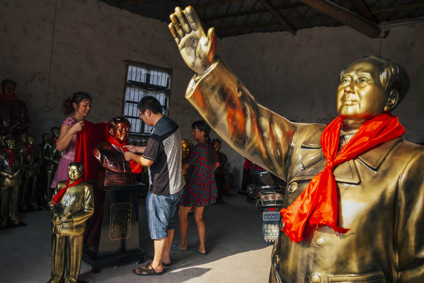 Xie Jinshan ties a red scarf around a newly minted Mao statue in Shaoshan, Sept. 16, 2015. Xu Xiaolin/Sixth Tone