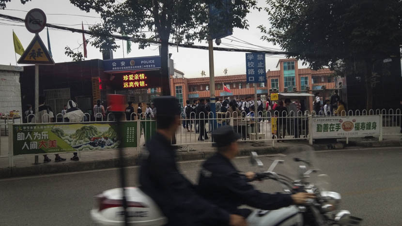 Two policemen patrol by motorcycle in front of Nayong No. 2 Middle School in Guizhou province, Nov. 24, 2015. Duan Yanchao/Sixth Tone