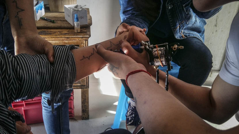 Ah Fei tattoos a customer at Er Tiao’s tattoo shop in Nayang, Guizhou province, Nov. 21, 2015. Duan Yanchao/Sixth Tone