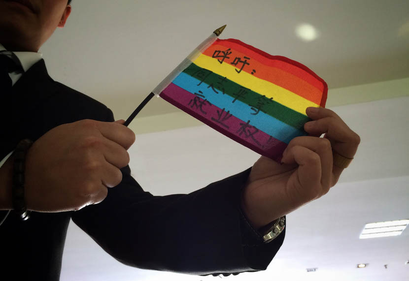 Mr. C displays a rainbow flag that reads ‘Call for equal employment rights for LGBT’ before the court hearing, in Guiyang, Guizhou province, April 8, 2016. Yang Xingbo, Li Jian/Guizhou City News for Sixth Tone