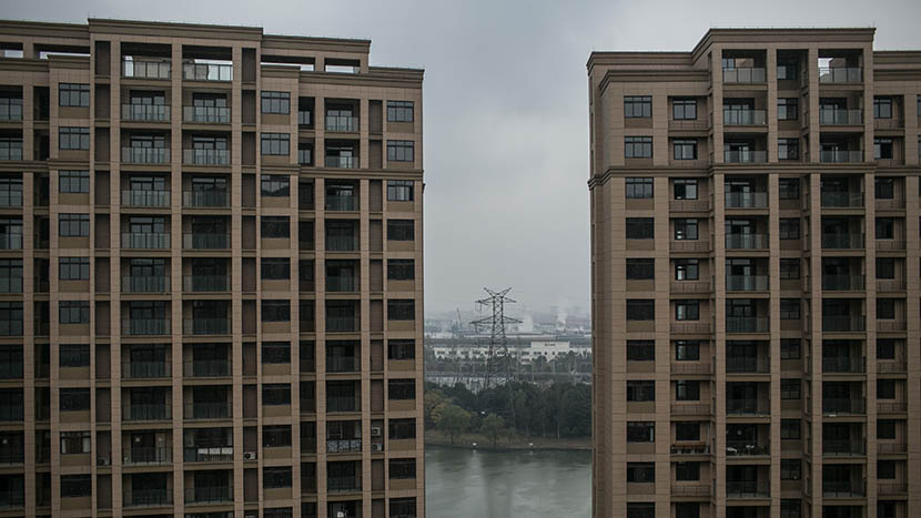 Factories seen through the window of a villager’s new home in a high-rise residence, Shaoxing, Zhejiang province, Dec. 5, 2015. Chen Ronghui/Sixth Tone