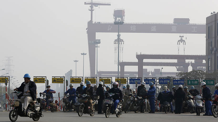Workers from the Rongsheng Heavy Industries shipyard ride motorcycles and e-bikes home after their shifts, Nantong, Jiangsu province, Dec. 4, 2013. Aly Song/Reuters