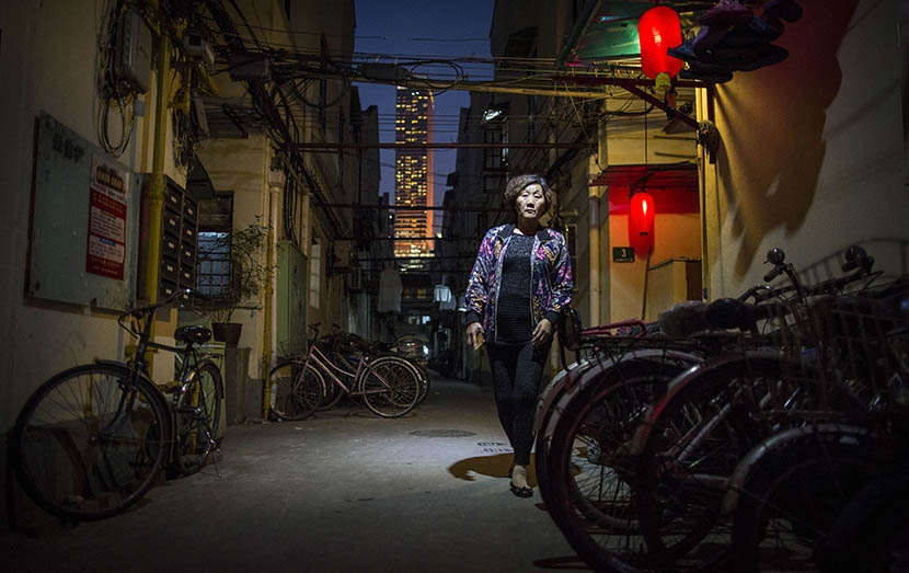 A woman in a lane on Changle Road is seen in front of an office building in Shanghai, May 11, 2016. Yang Shenlai/Sixth Tone