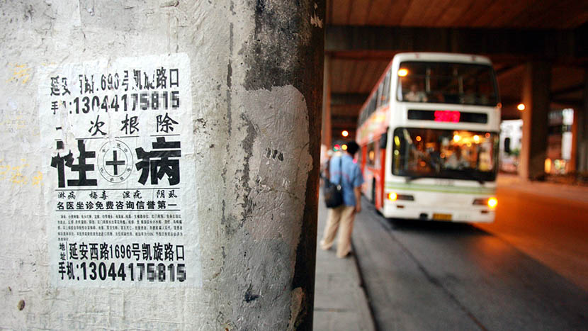 Illegal advertisement of sexually transmitted diseases pasted on a wall, Shanghai, Aug. 12, 2004. IC