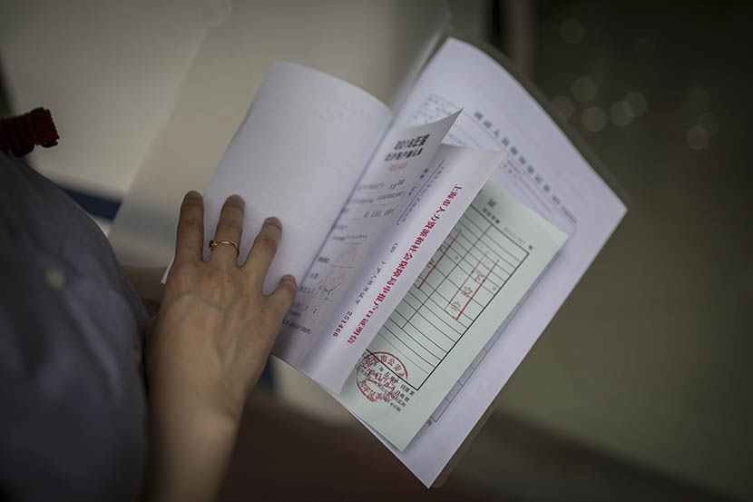 Lu Chen displays certificates and papers which are required in hukou application, Shanghai, May 5, 2016. Yang Shenlai/Sixth Tone