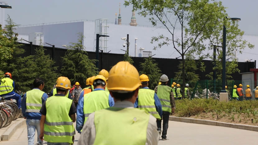 Workers walk to a construction site at Shanghai Disneyland, May 12, 2016. Liu Lu/Sixth Tone