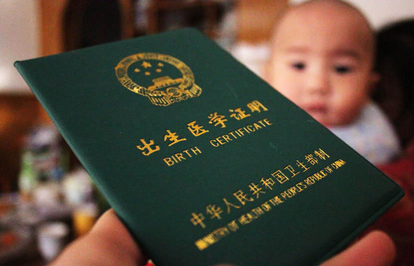 A birth certificate and its owner in Shiyan, Hubei province, Dec. 4, 2013. Zhang Xinjun/IC
